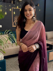 Woman in a pink saree with a dark background