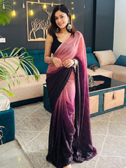 Woman wearing a pink and purple saree in a living room setting