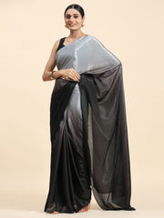 Woman wearing a black and gray saree on a beige background